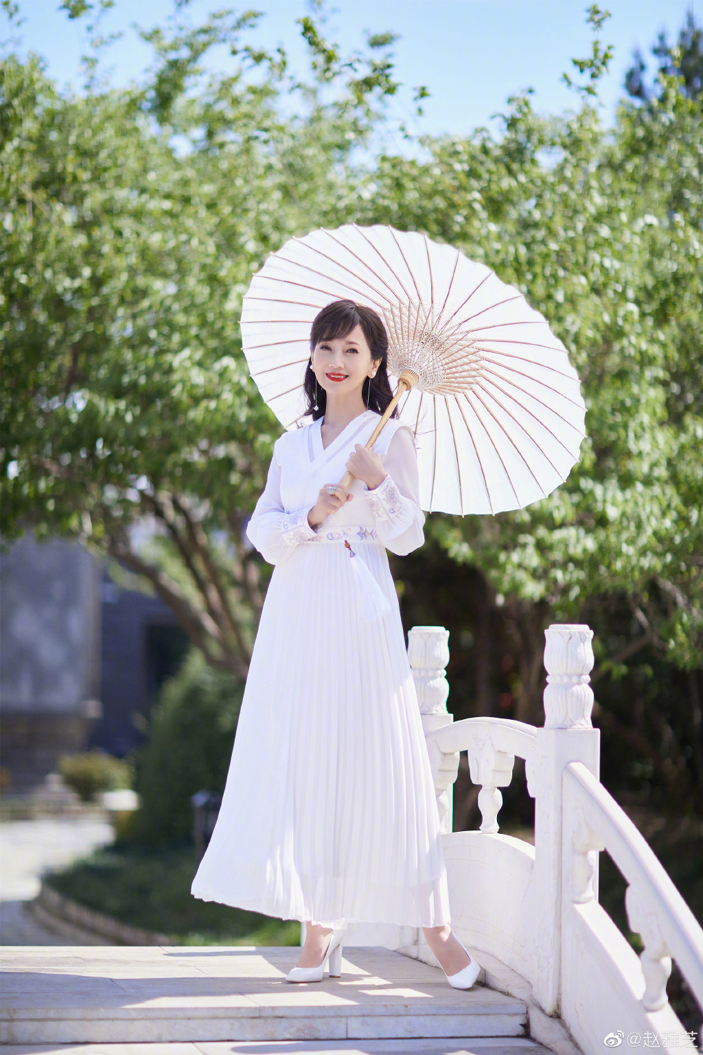 赵雅芝穿白裙优雅迷人 撑油纸伞漫步桥上  第1张